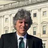 Joel McKinnon smiling in front of the U.S. Capitol building