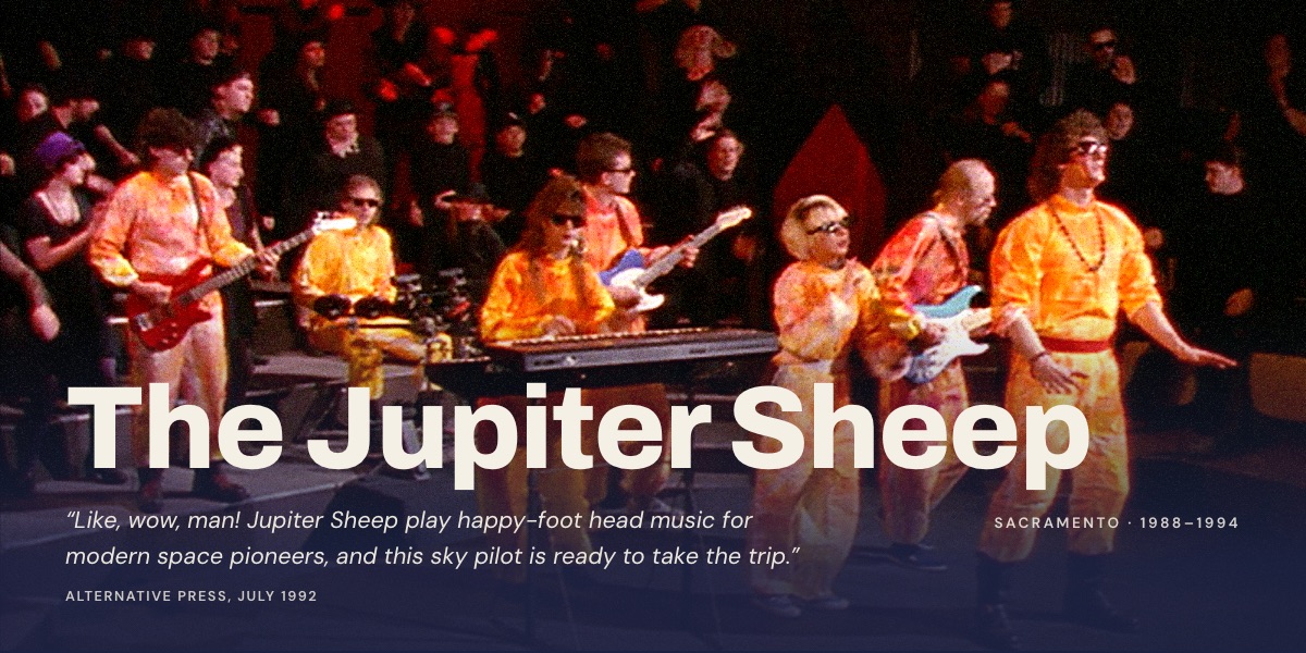 Home page of jupitersheep.com: a live stage photo of the band in orange jumpsuits beneath the headline "The Jupiter Sheep"